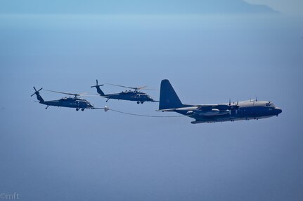 Two HH-60G Pave Hawk rescue helicopter and an MC-130P Combat Shadow aircraft, assigned to the 129th Rescue Wing, California Air National Guard, conduct an aerial refuel operations over the Pacific Ocean, April 3, 2014. 