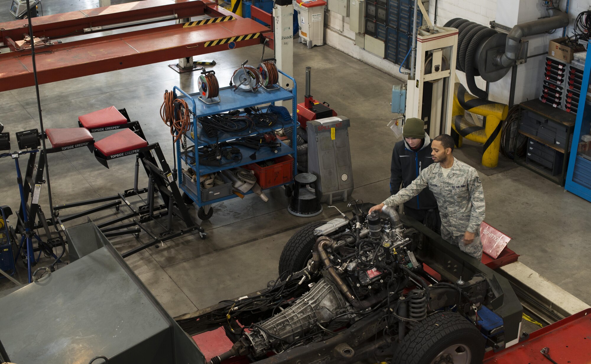 Staff Sgt. Travias Ellison, 86th Vehicle Readiness Squadron mission generation technician, teaches Hendrik Ecker, 86th VRS vehicle mechanic technician, about an international 6.0 liter engine at Ramstein Air Base, Germany, Nov. 14, 2016. Ecker partnered with the 86th VRS through Ramstein’s Local National Apprenticeship program, and will retain his position from three and-a-half to four years. Once the apprenticeship is complete, Ecker will have the opportunity to transfer to a permanent position in the area in vehicle maintenance. (U.S. Air Force photo by Senior Airman Tryphena Mayhugh)