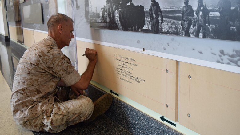 Lt. Gen. Rex C. McMillian, commander of Marine Forces Reserve and Marine Forces North, signs his name on the base board of the Marine Corps Reserve Centennial wall display at the Pentagon, Arlington, Va., Sept. 27, 2016, before the final segment is installed. The exhibit was installed at the Pentagon in conjunction with the 100th anniversary of the Marine Corps Reserve, which was celebrated Aug. 29, 2016. For more information on the history and heritage of the Marine Corps Reserve as well as current Marine stories and upcoming Centennial events, please visit www.marines.mil/usmcr100.