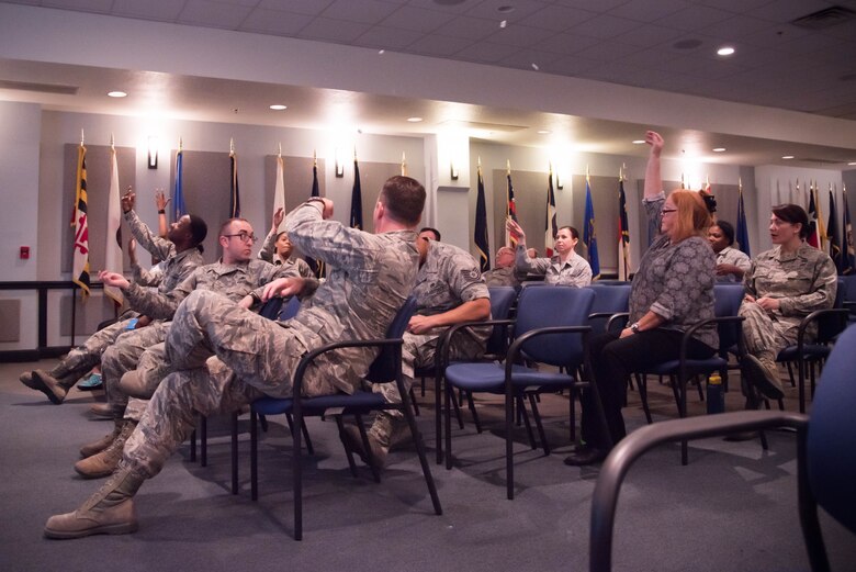 Green Dot training atendees throw pieces of paper  to one another during a class at Keesler Air Force Base, Miss. Nov. 5. that explain the different barriers bystanders may have to intervening in a negative situation. Green Dot is the U.S. Air Force's program to help raise awareness of and prevent sexual assault, domestic violence and stalking. (U.S. Air Force photo/Staff Sgt. Heather Heiney)