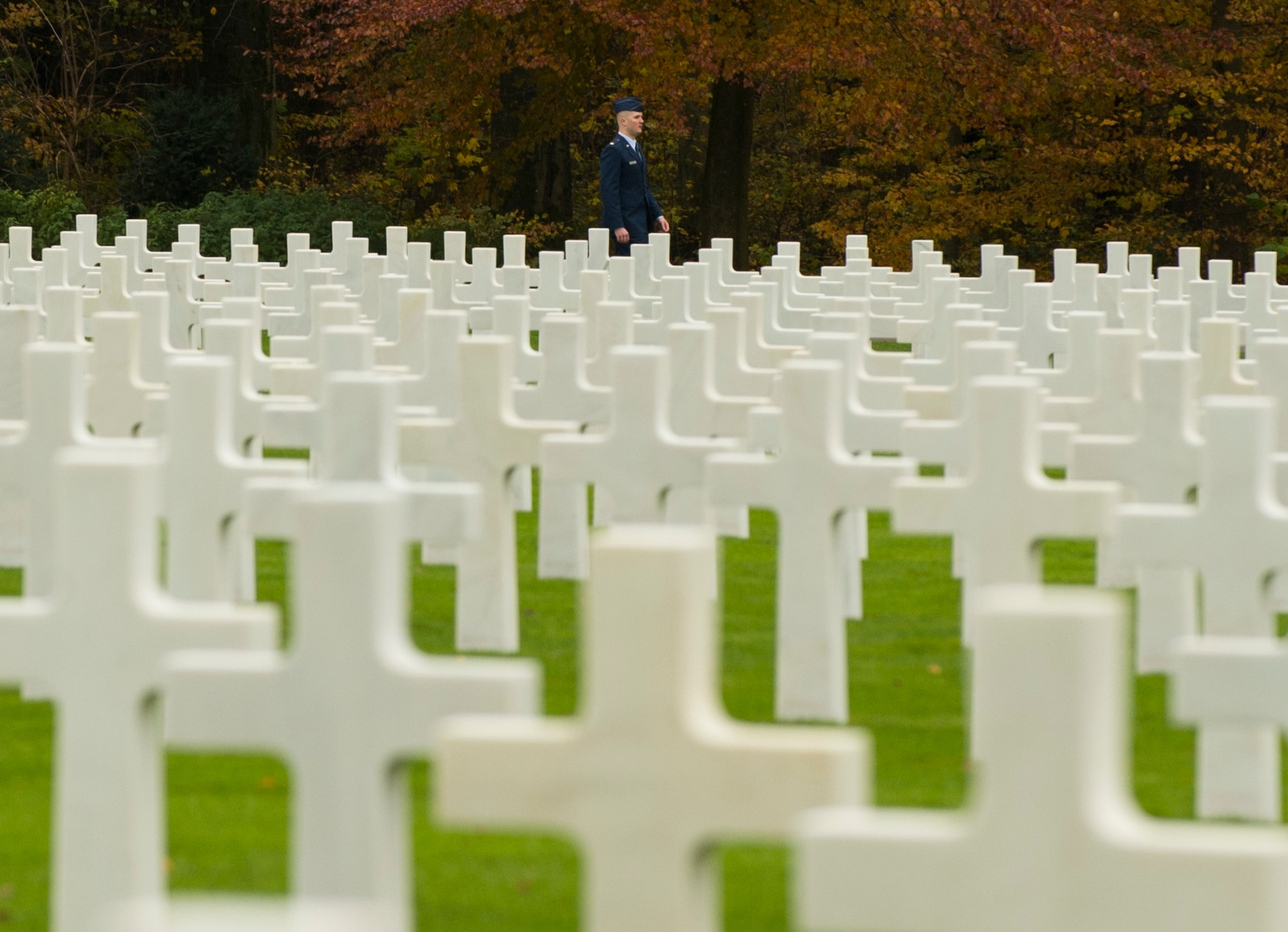 A U.S. Air Force Airman walks among white marble crosses and stars marking the burial sites of American service members at the Luxembourg American Cemetery and Memorial in Hamm, Luxembourg City, Luxembourg, Nov. 11, 2016. Approximately 5,076 U.S. service members who died during World War II are buried at this site. (U.S. Air Force photo by Senior Airman Dawn M. Weber)