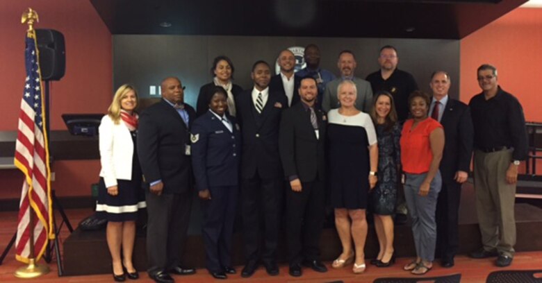 To commemorate Veteran's Day, Air Force Reservist Tech. Sgt. Angela Borders (front row, third from the left), 920th Force Support Squadron, Patrick Air Force Base, Florida, poses with a group of new U.S. citizens which were part of U.S. Citizenship and Immigration Services Ceremony which she led November 8, 2016. Borders works as an Immigration Services Officer in Orlando when she's not serving the country. (Courtesy photo)