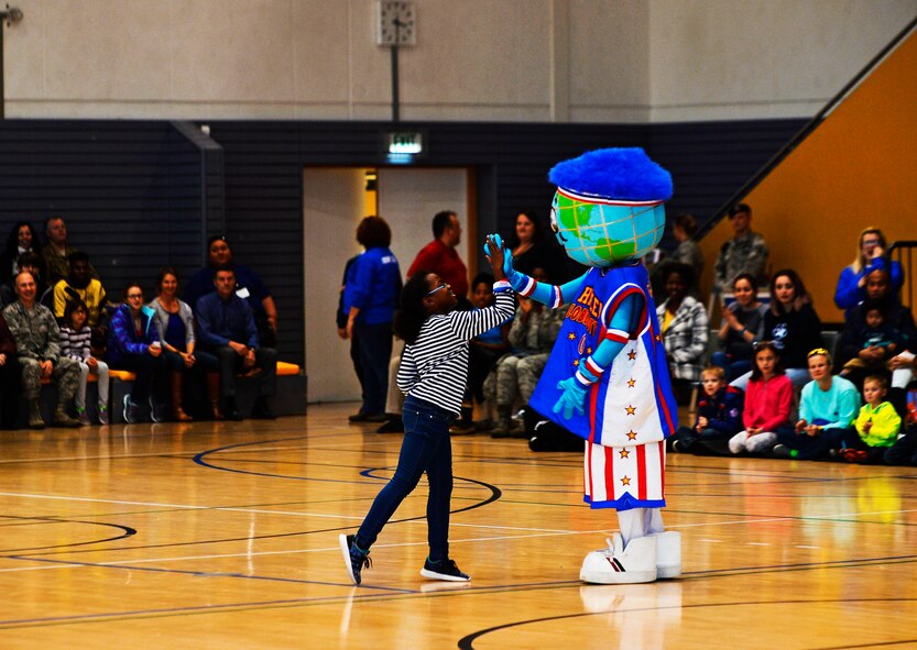 Globie, the Harlem Globetrotters mascot, gives an audience member a high-five during a performance at Ramstein Air Base, Germany, Nov. 10, 2016. The 86th Force Support Squadron, Armed Forces Entertainment, and Navy Entertainment brought the Harlem Globetrotters to Ramstein in order to boost the morale of Department of Defense members and their families. The basketball exhibition team combines elements of sports, theater, and comedy to produce entertaining shows for its audiences.  (U.S. Air Force photo by Airman 1st Class Joshua Magbanua)