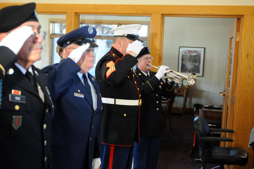 WAUWATOSA, Wisconsin (November 9, 2016) – Army Staff Sgt. Christy Gervais, left, 484th Army Band, plays the National Anthem during the Luther Manor Veterans Memorial dedication ceremony, November 9, while members of the Milwaukee NCO Council salute. The ceremony marked the unveiling of the memorial that honors the more than 120 veteran residents of Luther Manor as well as all those that have and will live there.