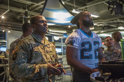 Capt. Jerome Russell, Operations Officer, with the 108th Training Command (Initial Entry Training), plays against Michael Griffin, a Safety for the Carolina Panthers, during the Pro vs. GI Joe video game challege in Charlotte, N.C., Nov. 7, 2016. (U.S. Army Reserve photo by Sgt. Stephanie A. Hargett/ released)