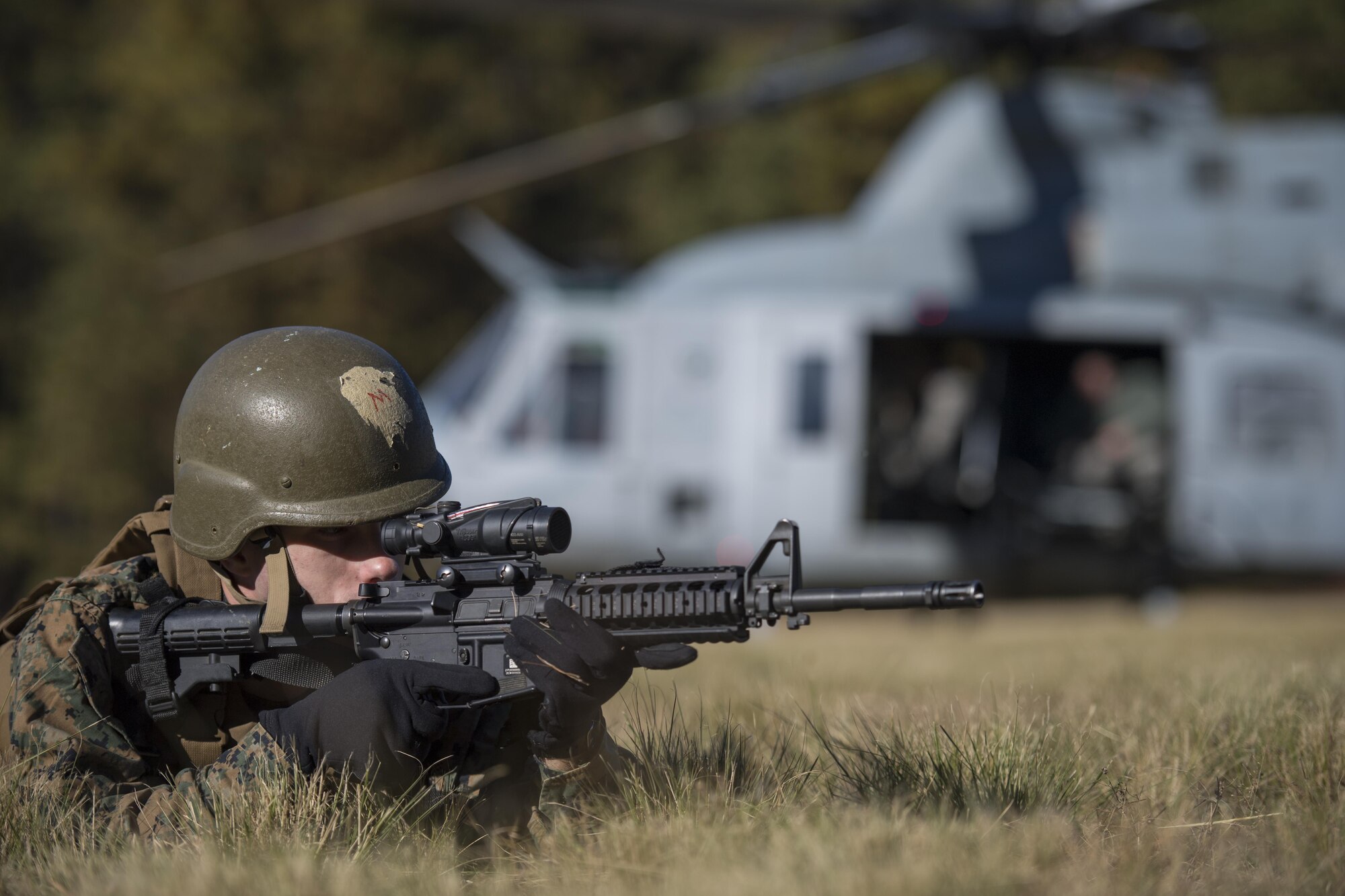 A marine with the Marine Aircraft Group 49, scans the tree line for simulated enemies during a rescue exercise that took place during the Advanced Combat Operations and Tactics exercise at Joint Base McGuire-Dix-Lakehurst, New Jersey, Nov. 8, 2016. The MAG 49 picked up 5 simulated isolated Airmen as part of a Survival, Evasion, Resistance and Escape exercise. 