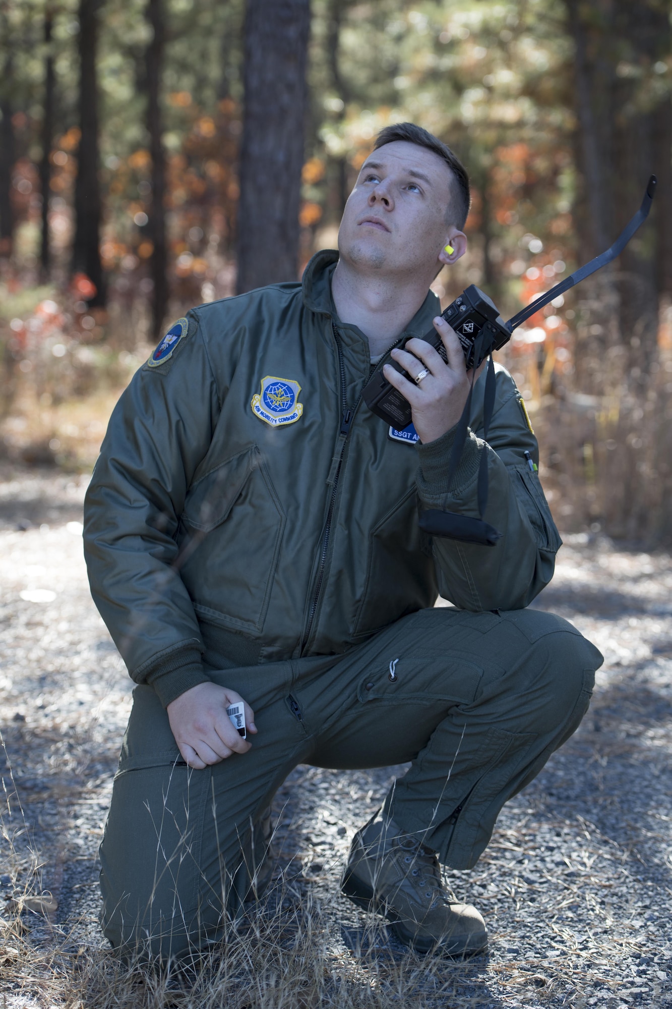 Staff Sgt. Andy Keiser, a 32nd Air Refueling Squadron boom operator, communicates with a refueler circling above to secure his and four other Airmen's rescue during a Survival, Evasion, Resistance and Escape exercise at Joint Base McGuire-Dix-Lakehurst, New Jersey, Nov. 8, 2016. After communicating their location with the refueler using an encrypted radio code, the simulated isolated Airmen were rescued by the Marine Aircraft Group 49.