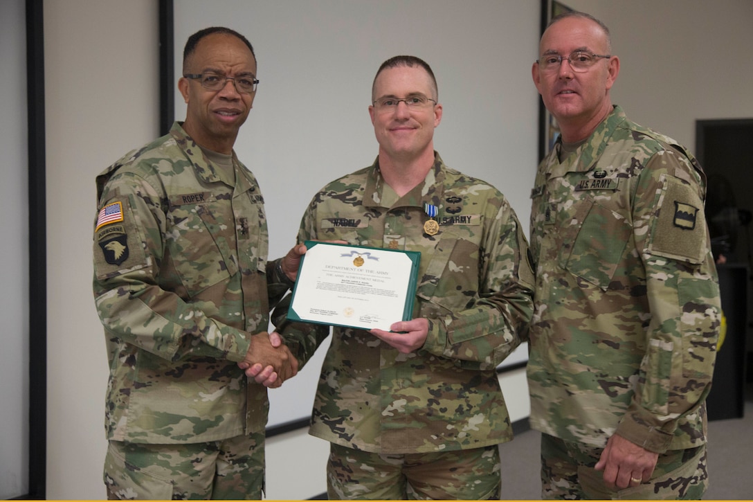 Maj. Gen. A.C. Roper, commander of the 80th Training Command, and Command Sgt. Maj. Jeffrey Darlington, command sergeant major of the 80th, present Maj. Jason Nagel with the Army Achievement Medal for earning top honors as the Officer Instructor of the Year at the 80th's 2016 IOY competition at Fort Knox, Ky., Oct. 23, 2016. Photo by Spc. Sarah Ruiz, 55th Signal Company (Combat Camera).