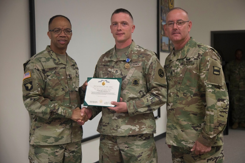Maj. Gen. A.C. Roper, commander of the 80th Training Command, and Command Sgt. Maj. Jeffrey Darlington, command sergeant major of the 80th, present Sgt. 1st Class Kevin Hiles with the Army Achievement Medal for winning the Noncommissioned Officer Instructor of the Year at the 80th's 2016 IOY competition at Fort Knox, Ky., Oct. 23, 2016. Photo by Spc. Sarah Ruiz, 55th Signal Company (Combat Camera).