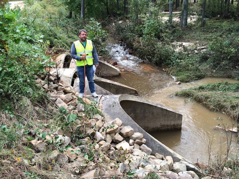 Patrick Hager, a Savannah District structural engineer, stands above a water crossing during infrastructure assessments conducted at Fort Bragg in North Carolina Oct. 14, 2016. The water crossing consists of three concrete culverts that direct the outflow from a connected lake. The inlet caps on the upstream side separated from concrete pipes but showed no considerable damage. 