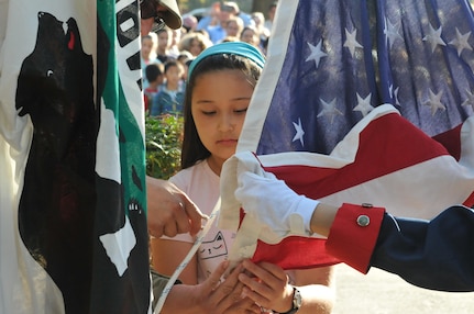 Assisted by Sgt. Arleen Banioza (right), color guard noncommissioned officer, 63rd Regional Support Command, and Staff Sgt. Juan Martinez (left), senior human resource specialist, 63rd RSC, fourth grader Amy Pietromanco (center) helps raise the U.S. flag during a flag raising ceremony, Nov. 10, Christa McAuliffe Elementary School, Saratoga, Calif. (U.S. Army Reserve photo by Alun Thomas, 63rd RSC Public Affairs)