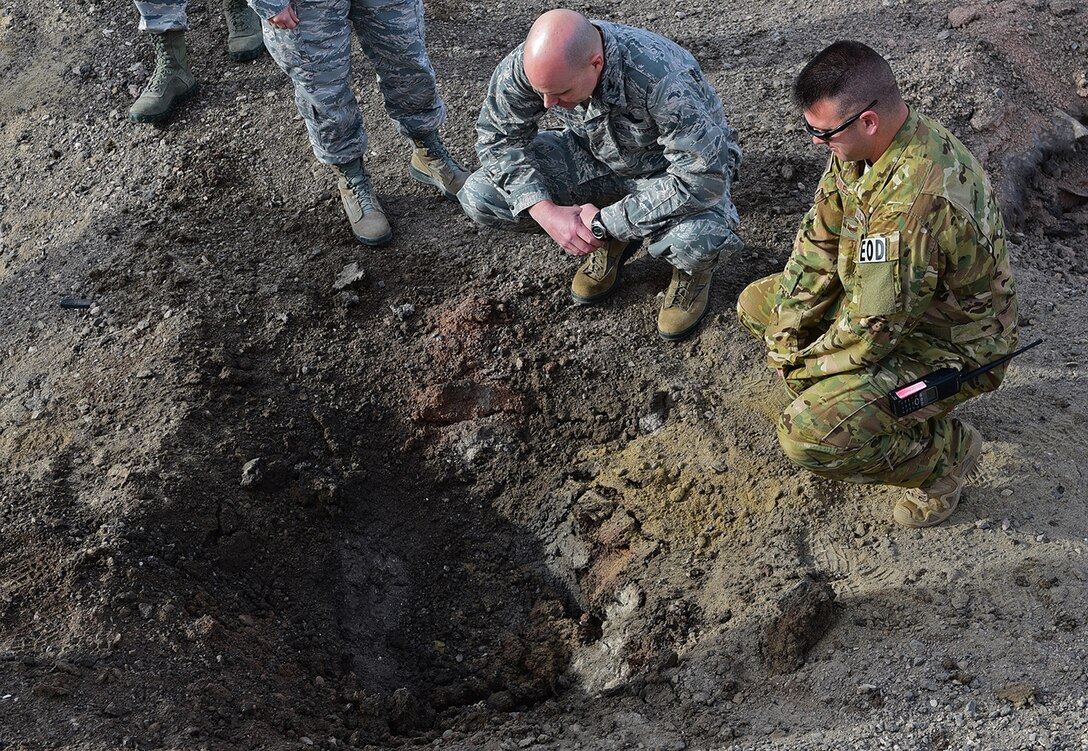 Col. Bradley Cochran, vice commander of the 28th Bomb Wing, examines the crater left from the explosives he triggered at Ellsworth Air Force Base, S.D., Nov. 14, 2016. The hole was created by less than five pounds of explosives, which demonstrates the impact small improvised explosive devices can cause. (U.S. Air Force photo by Airman 1st Class James L. Miller)