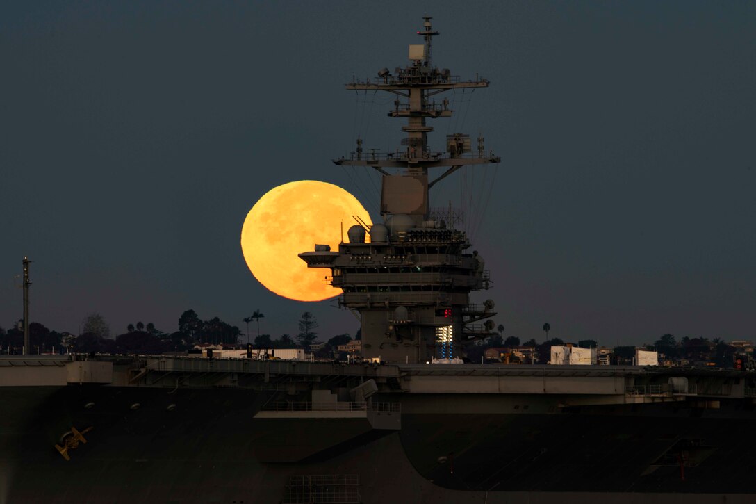 The brightest moon in almost 69 years sets behind the aircraft carrier USS Theodore Roosevelt in Coronado, Calif., Nov. 14, 2016. Navy photo by Petty Officer 2nd Class Abe McNatt