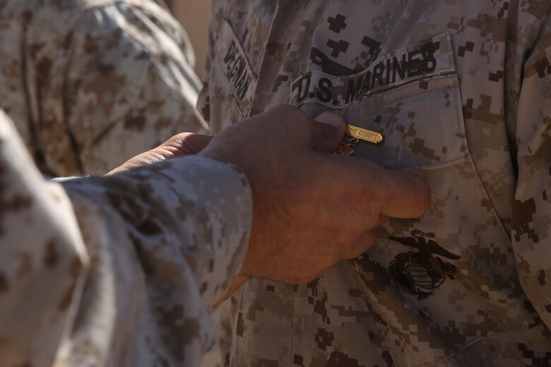 Maj. Gen. Daniel O’Donohue, the 1st Marine Division commanding general, pins a Marine with a super squad badge aboard Marine Corps Air-Ground Combat Center Twentynine Palms, Calif., Aug. 15, 2016. The Marines received the engraved badges for placing first in the 1st Marine Division Super Squad Competition that took place in July. (U.S. Marine Corps photo by Cpl. Timothy Valero)