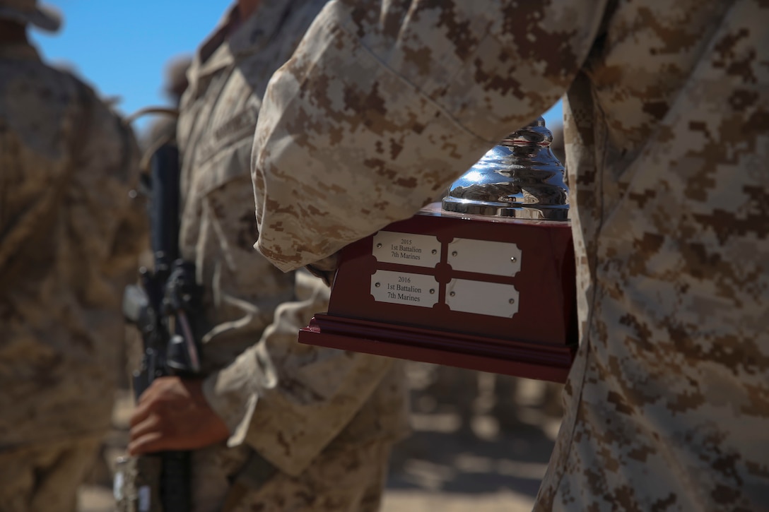 Sgt. Derrick Higgs, a squad leader with Company C, 1st Battalion, 7th Marine Regiment, holds the Mitchell Cup after a ceremony to recognize his squad’s victory aboard Marine Corps Air-Ground Combat Center Twentynine Palms, Calif., Aug. 15, 2016. The Marines also received individually engraved badges for placing first place in the 1st Marine Division Super Squad Competition which took place in July.  (U.S. Marine Corps photo by Cpl. Timothy Valero)