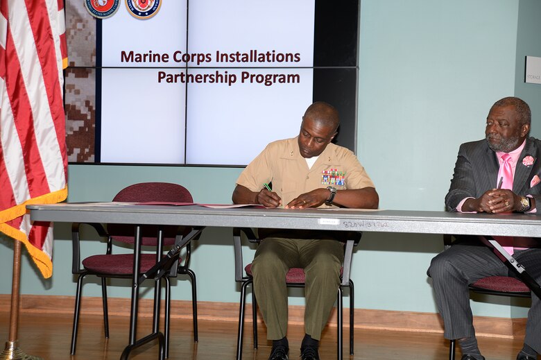 Col. James C. Carroll III, commanding officer, Marine Corps Logistics Base Albany, left, signs an educational partnership agreement with Dr. Anthony Parker, president, Albany Technical College at ATC, Albany, Ga., recently.

