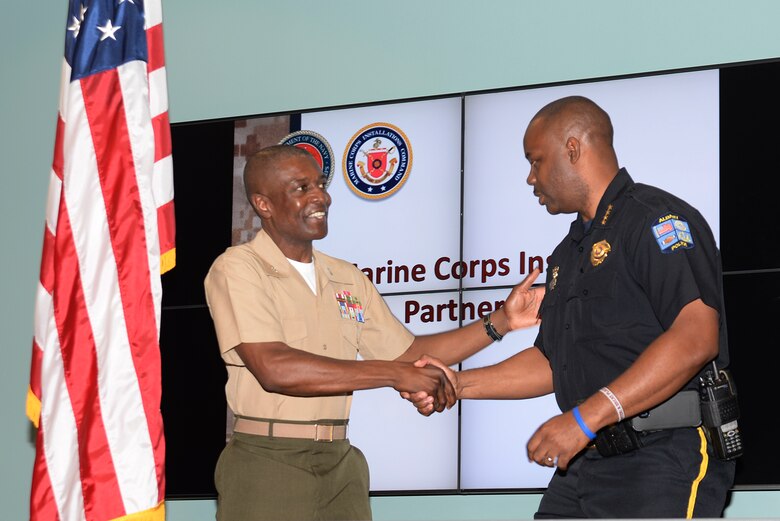 Col. James C. Carroll III, commanding officer, Marine Corps Logistics Base Albany, left, congratulates Michael Persley, chief of police, City of Albany, on their new S.W.A.T. partnership agreement at Albany Technical College, Albany, Ga., recently.

