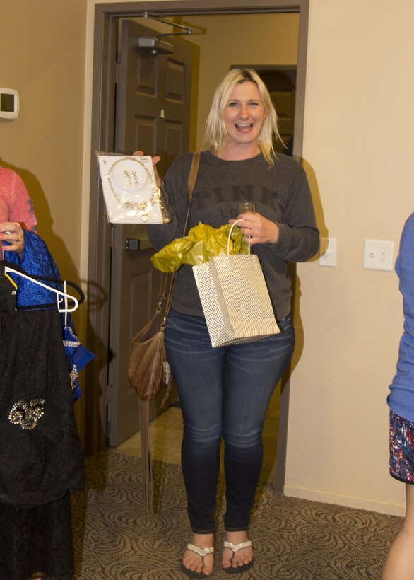 Sierra Avery, a Marine spouse, poses with her raffle prize during Operation: My Girlfriend's Closet event held aboard Marine Corps Logistics Base Barstow, Calif., Nov. 9. The event, hosted by Leslie Beberniss, also a Marine spouse, and her family's business, DRYFEK Inc., allows military spouses an opportunity to enjoy refreshments and prizes while picking out a gown for the upcoming Marine Corps Birthday Ball. 