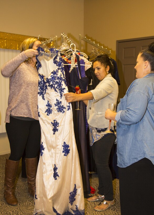 Leslie Beberniss, hostess of Operation: My Girlfriend's Closet, and her helper, Melissa Kratzer assist Alma Martinez in picking out a gown or two during the event held aboard Marine Corps Logistics Base Barstow, Calif., Nov. 9. All three women are Marine spouses and the event, sponsored by DRYKEF Inc. allows military spouses to enjoy refreshments and prizes while picking out a gown for the Marine Corps Ball. 