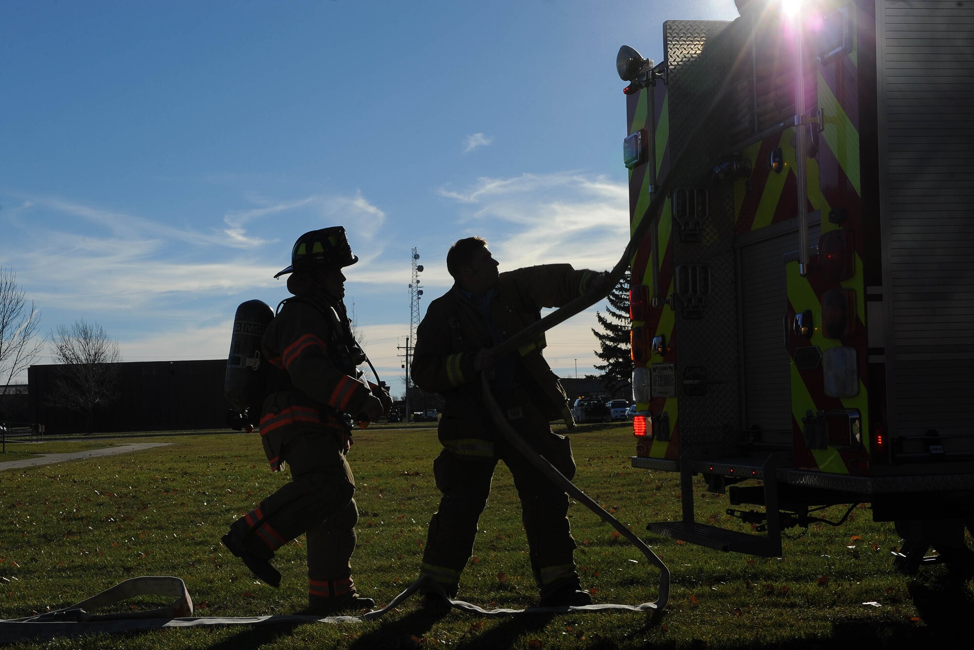 Firefighters from the 5th Civil Engineer Squadron pull a hose from a fire engine during a training exercise at Minot Air Force Base, N.D., Nov. 9, 2016. The fire protection flight’s goal is to protect Team Minot, property and the environment from fires and disasters through fire prevention, firefighting, rescue and hazardous material response. (U.S. Air Force photo/Senior Airman Kristoffer Kaubisch)