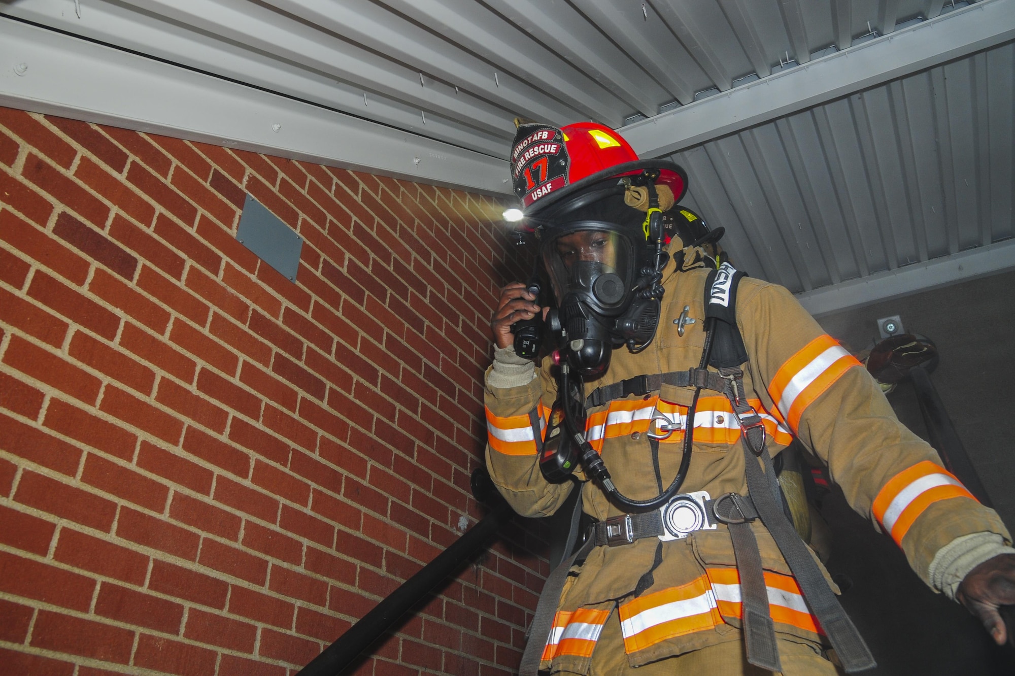 Senior Airman Brandon Vernon, 5th Civil Engineer Squadron firefighter, radios other firefighters during a training exercise at Minot Air Force Base, N.D., Nov. 9, 2016. During the exercise, the flight responded to a call, searched a building for victims and determined the cause of the fire. (U.S. Air Force photo/Airman 1st Class Christian Sullivan)
