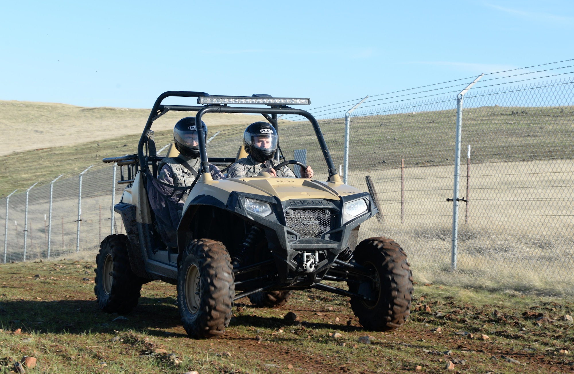 Senior Airman David Gill, 9th Security Forces Squadron base defense operation controller, and Airman 1st Class Luis Valentin, 9th SFS installation entry controller, drive an all-terrain vehicle alongside a fence line Nov. 4, 2016, at Beale Air Force Base, California. The perimeter of Beale is 26 miles and is broken up into six sectors. (U.S. Air Force photo/Airman Tristan D. Viglianco)