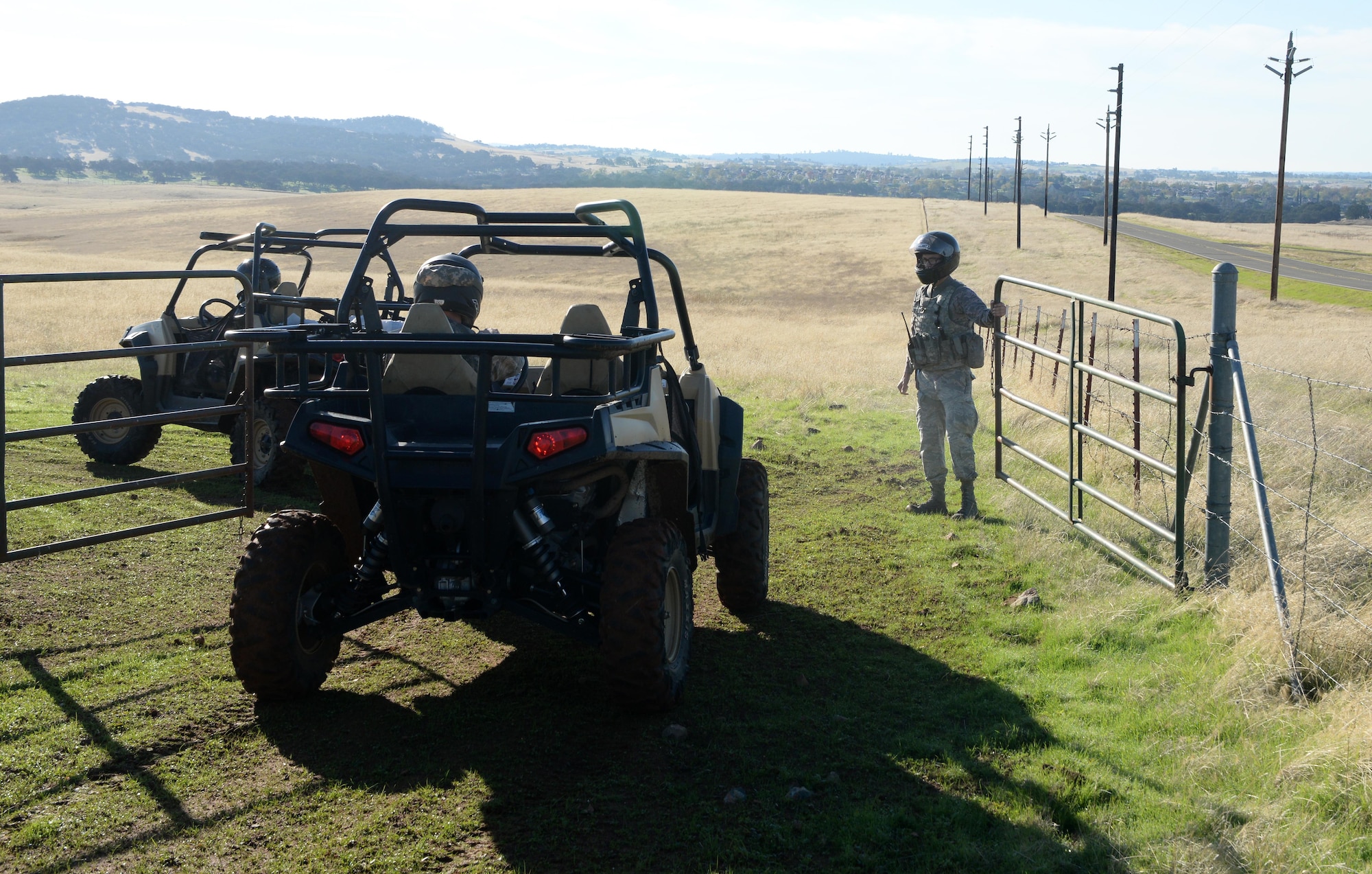 Airman 1st Class Luis Valentin, 9th Security Forces Squadron installation entry controller, opens a gate for the all-terrain vehicles to drive through Nov. 4, 2016, at Beale Air Force Base, California. On coyote patrols security forces' personnel inspect the fence line and gates on the outskirts of the installation. (U.S. Air Force photo/Airman Tristan D. Viglianco)