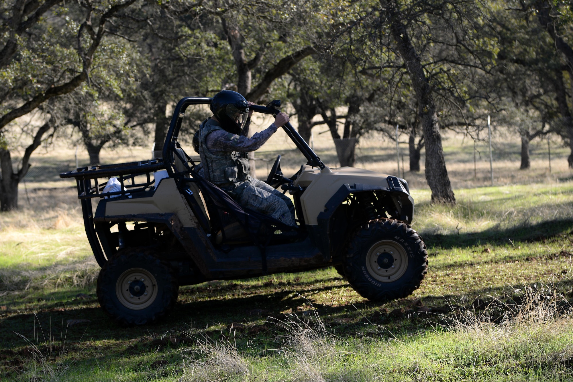 Airman 1st Class Luis Valentin, 9th Security Forces Squadron installation entry controller, climbs into an all-terrain vehicle in a wooded area at Beale Air Force Base, California, Nov. 4, 2016. Much of the perimeter of Beale is secluded by wooded areas. (U.S. Air Force photo/Airman Tristan D. Viglianco)