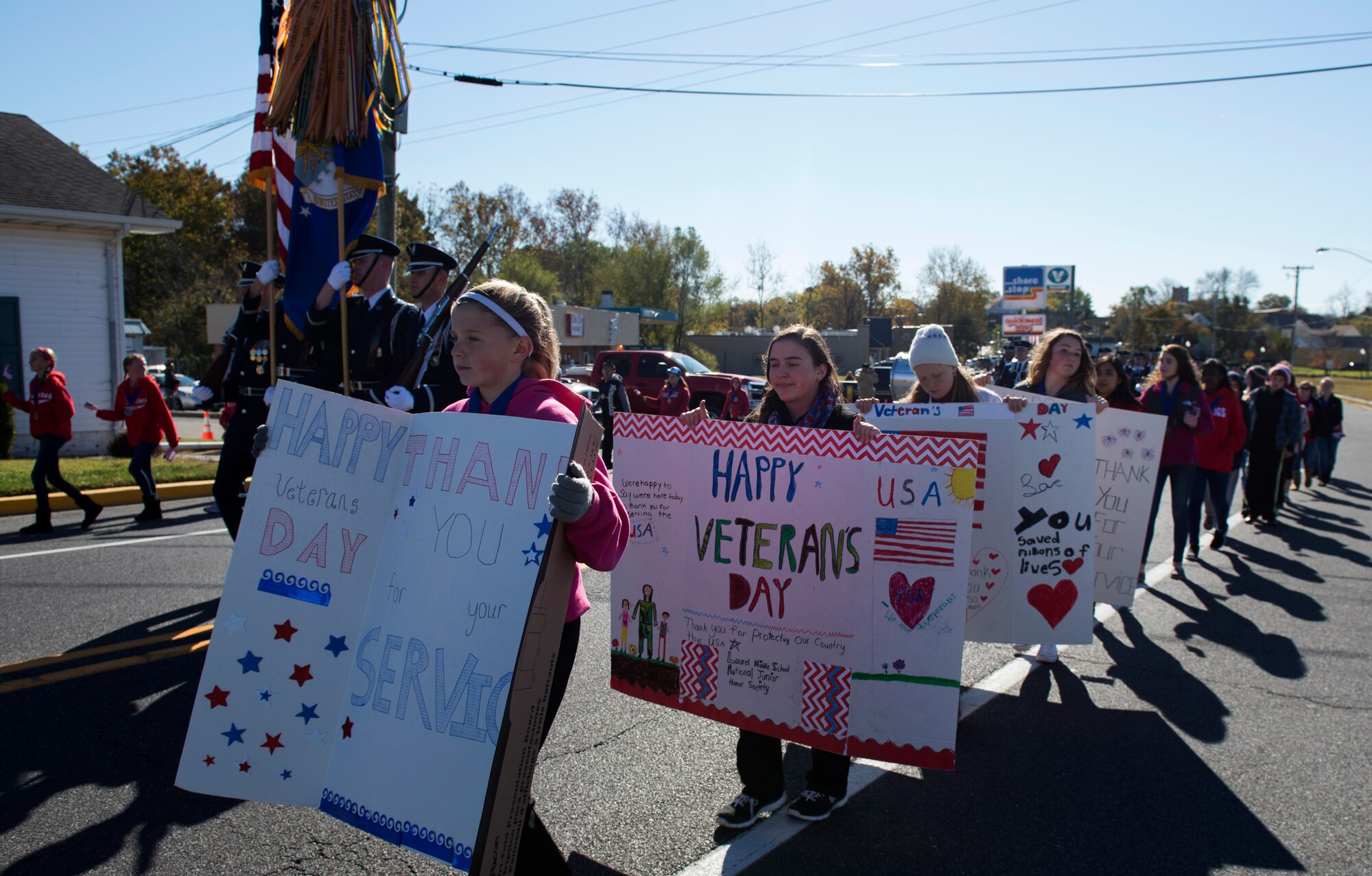 Children with signs and flags walked alongside the U.S. Air Force Honor Guard as they march in the 4th Annual Veterans Day Parade in Laurel, Del., Nov. 12, 2016. Laurel is a small city with a population of approximately 3,700, most taking part in the parade. (U.S. Air Force photo by Senior Airman Philip Bryant)