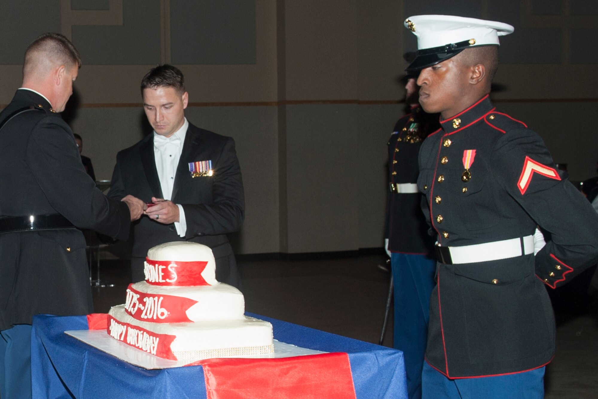 U.S. Marine Corps Maj. Andrew Armstrong, Marine Corps Detachment Goodfellow Commanding Officer, hands the first piece of birthday cake to retired Cpl. Garrett Jones during the Marine Corps ball at the McNease Convention Center, San Angelo, Texas, Nov. 12, 2016. Marine tradition dictates the commander cut the cake and provide the first piece to the guest of honor. (U.S. Air Force photo by Staff Sgt. Laura R. McFarlane/Released)