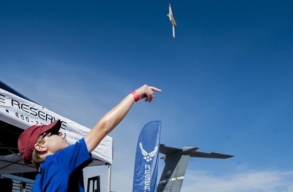 A boy throws a model airplane during the Aviation Nation air show on Nellis Air Force Base, Nev., Nov. 12, 2016. Aviation Nation provided the community the opportunity to interact with Airmen. (U.S. Air Force photo by Airman 1st Class Kevin Tanenbaum/Released)