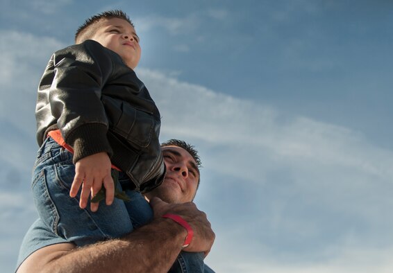 A young child sits on his father’s shoulders during aerial performances at the Aviation Nation air show on Nellis Air Force Base, Nev., Nov. 12, 2016. This event also marked the end of the air show season for the U.S. Air Force Air Demonstration Squadron, the Thunderbirds. (U.S. Air Force photo by Airman 1st Class Kevin Tanenbaum/Released)