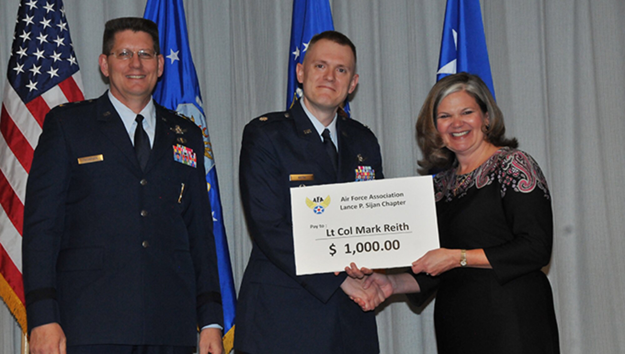 Several Airmen received prizes and recognition at an award ceremony on Nov. 15, 2016 at Peterson AFB for their winning essays in the 2016 Gen. Bernard A. Schriever Memorial Essay Contest.  Pictured from left to right are AFSPC vice commander Maj. Gen. David Thompson, Open Division winning essay author Lt. Col. Mark Reith and incoming AFA Lance P. Sijan Chapter president Kristen Christy