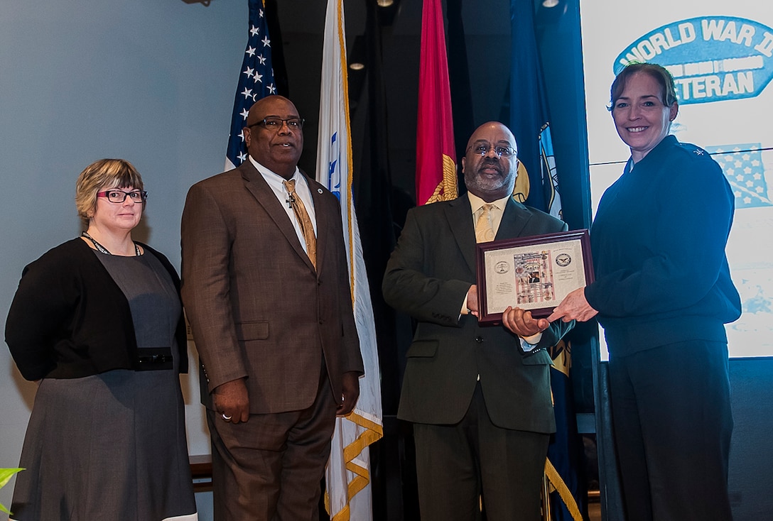 DSCC celebrated Veterans Day Nov. 9 at its annual program and benefits fair. Mr Alphonsa Green (3rd from left) was the guest speaker. Presenting Green with a memento is (l-r): Terri Hilton, DFAS-Columbus Veterans Program; Anthony Stone, DLA Land and Maritime Veterans Program; Green; Rear Adm. Michelle Skubic, Land and Maritime commander. 