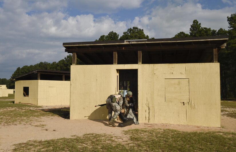 U.S. Air Force Senior Airman Derrik Florkiewicz, 628th Communications Squadron member and Staff Sgt. Sarah Woods, 628th Medical Group member drag a simulated casualty inside a building for cover during the first Joint Base Charleston Combat Skills Training course here, Sept. 29, 2016. Members treated the simulated casualty as part of a care under fire training scenario.