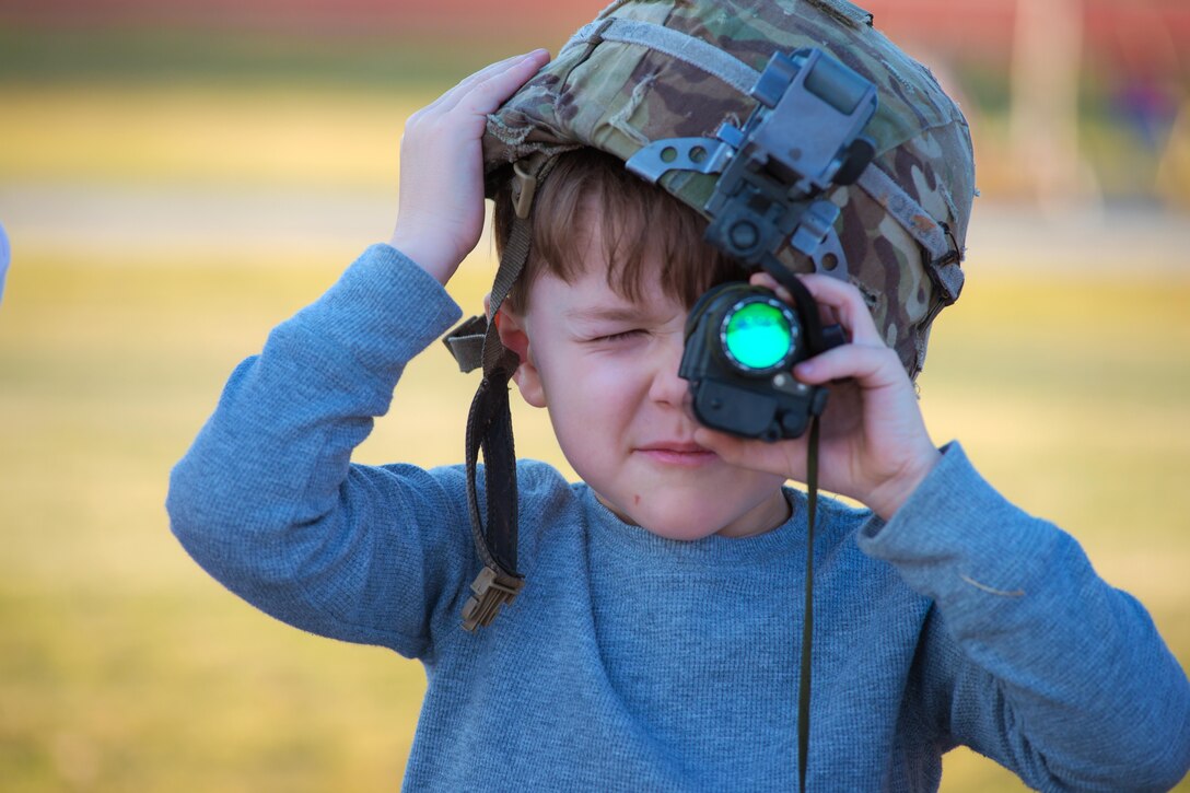 An Army family member peers through an optic at a static display during Marne Week at Fort Stewart, Ga., Nov. 15, 2016. Marne Week includes a series of activities for soldiers and family members celebrating the anniversary of the 3rd Infantry Division, nicknamed the Marne Division. Army photo by Lt. Col. Brian J. Fickel