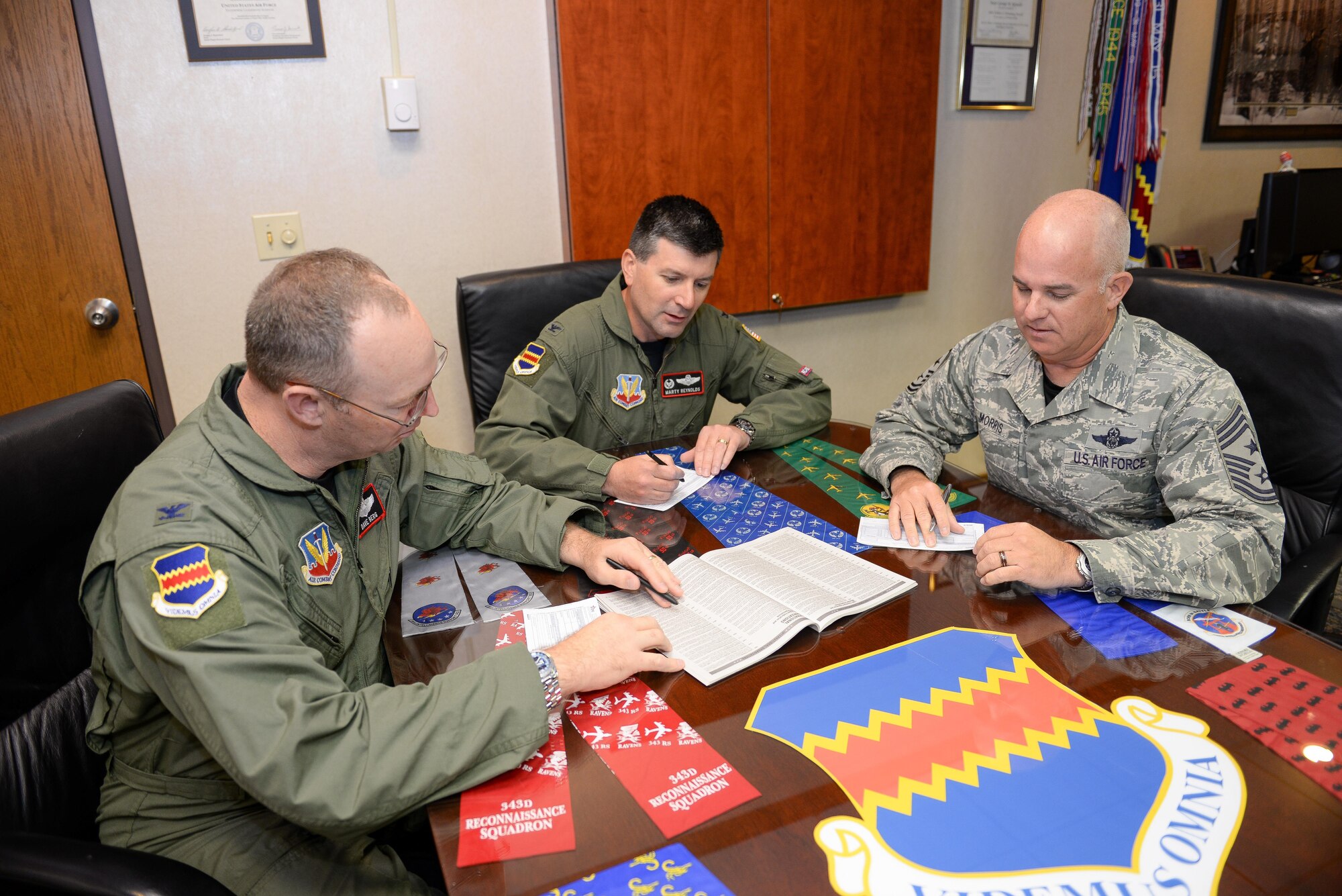 U.S. Air Force Col. Marty Reynolds (middle), 55th Wing commander, U.S. Air Force Col. David Berg (left), 55th Wing vice commander, and U.S. Air Force Chief Master Sgt. Michael Morris, 55th Wing command chief, sign Combined Federal Campaign letters in the wing headquarters building at Offutt Air Force Base, Neb., Oct. 7, 2016. The CFC is an annual fundraising drive that provides an opportunity for federal civilian, postal and military employees to donate to local, national and international non-profit organizations. (U.S. Air Force photo by Zachary Hada)