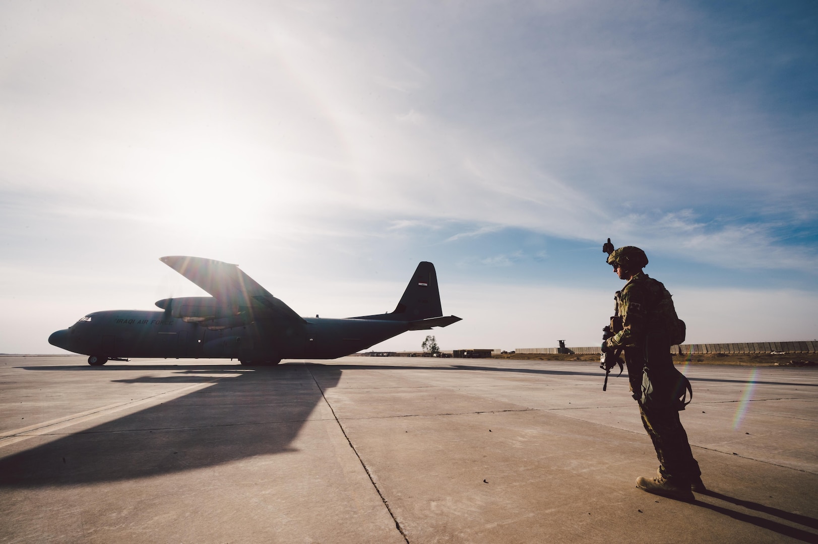 Senior Airman Zachery Hatfield, 821st Contingency Response Squadron crew chief, provides airfield security for an Iraqi air force C-130 at Qayyarah West Airfield, Iraq, in support of Combined Joint Task Force - Operation Inherent Resolve, Nov. 13, 2016. The 821st CRG is highly-specialized in training and rapidly deploying personnel to quickly open airfields and establish, expand, sustain and coordinate air operations in austere, bare-base conditions. (U.S. Air Force photo by Senior Airman Jordan Castelan)