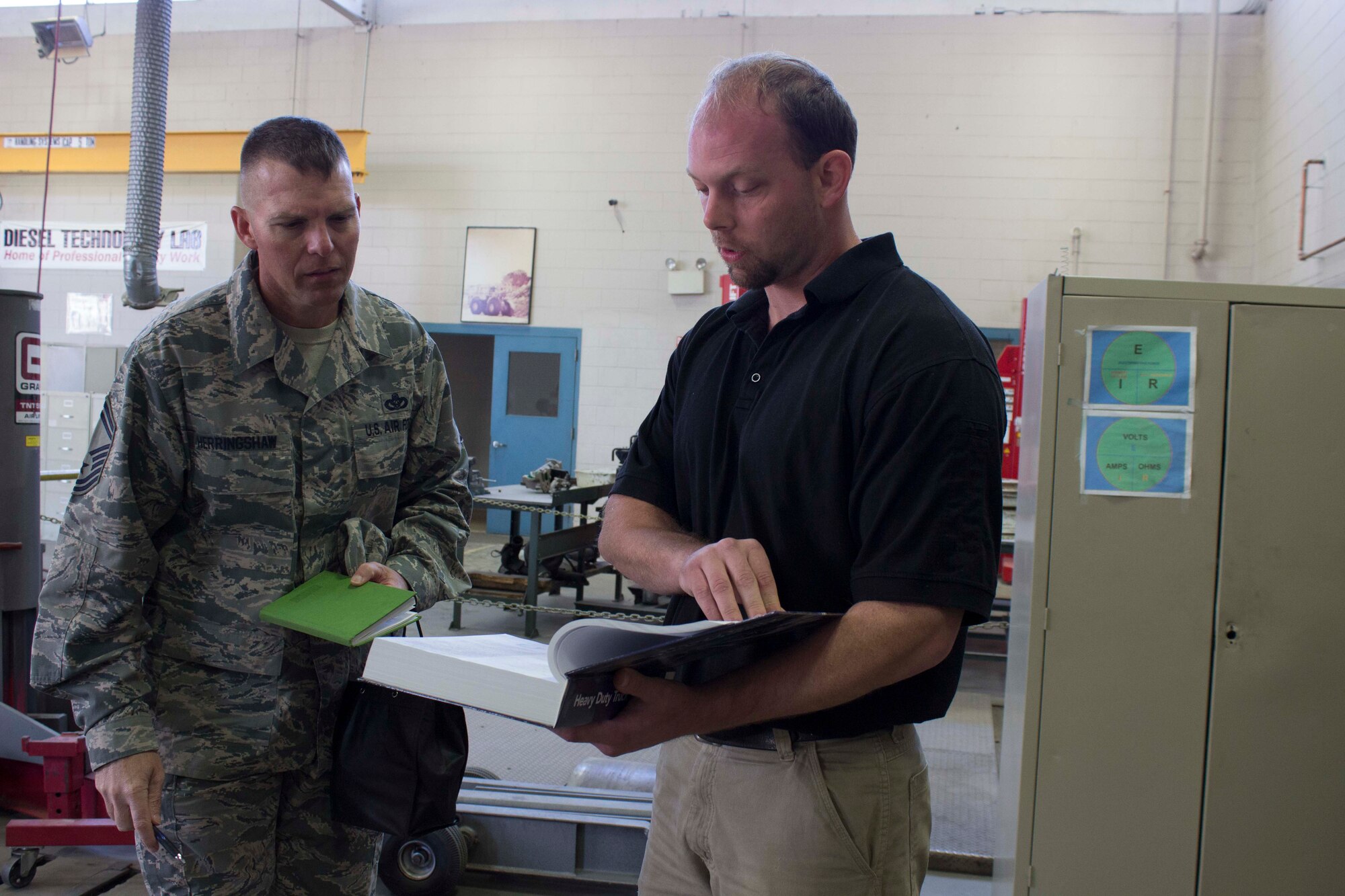 Senior Master Sgt. Stewart Herringshaw reviews instructional materials with Craig Kelly at South Georgia Technical College in Americus, Georgia, during a training discussion while on a tour of the college. Herringshaw recently visited the college to collaborate with instructors and leaders on training efforts and training needs for power pro technicians. (U.S. Air Force Photo/Susan Lawson)