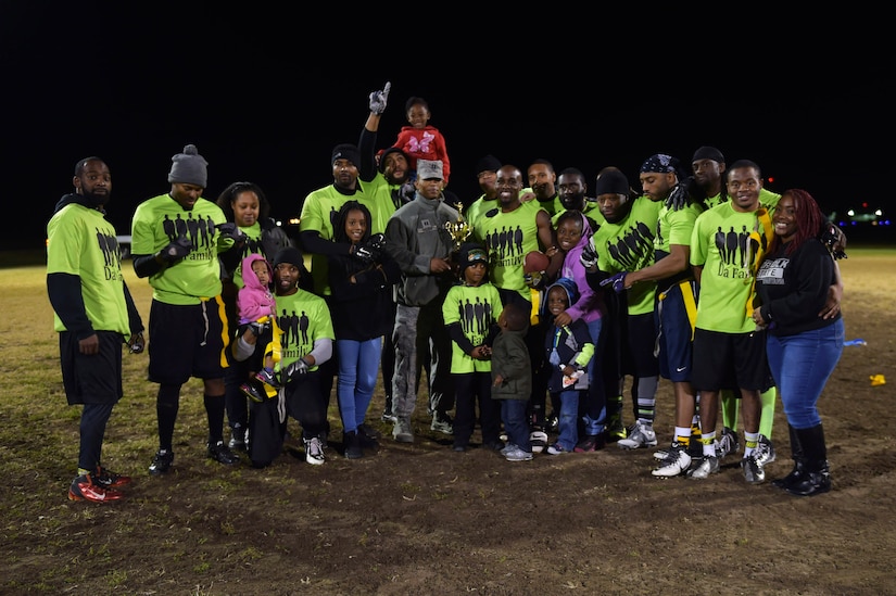 Team members and family from the Ryan Center pose with the winning trophy after the Intramural Football Championship game at Joint Base Langley-Eustis, Va., Nov. 10, 2016. After starting the football season and competing against more than 15 other teams, the Ryan Center won during the championship game. (U.S. Air Force photo by Senior Airman Kimberly Nagle)