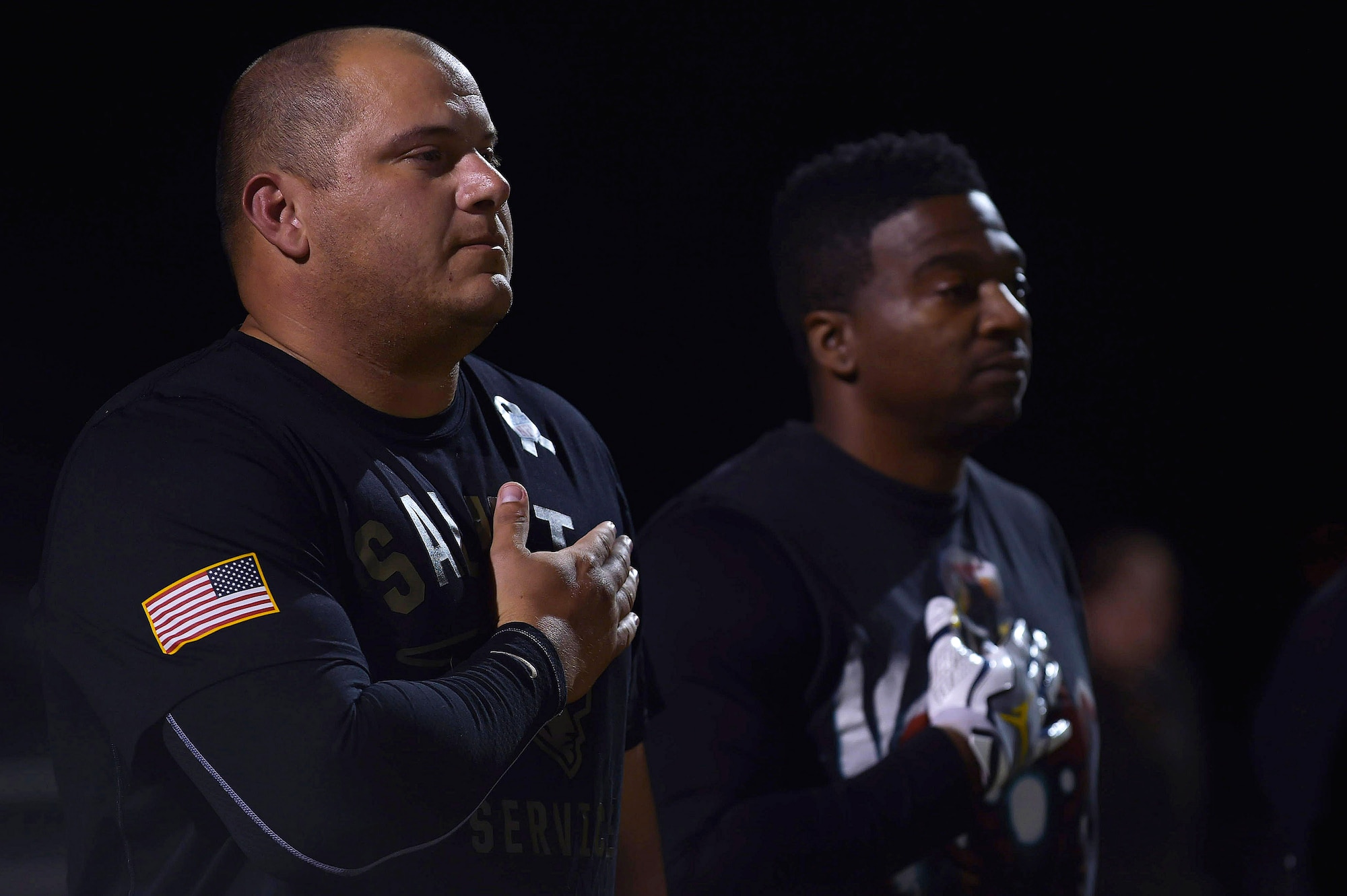 U.S. Air Force Staff Sgt. Alan Shea, 497th Intelligence, Surveillance and Reconnaissance Wing team captain, holds his hand over his heart during the playing of the National Anthem during the Intramural Football Championship game at Joint Base Langley-Eustis, Va., Nov.10, 2016. Members of the Langley Honor Guard presented the colors during the playing of the National Anthem. (U.S. Air Force photo by Senior Airman Kimberly Nagle)