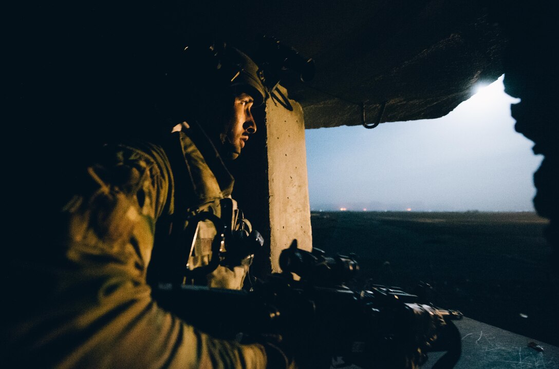 Senior Airman Ralph Hoeflich, 821st Contingency Response Group close precision engagement airman, scans a field illuminated by a flare from inside a defensive fighting position at Qayyarah West Airfield, Iraq, in support of Combined Joint Task Force - Operation Inherent Resolve, Nov. 14, 2016. The 821st CRG is highly-specialized in training and rapidly deploying personnel to quickly open airfields and establish, expand, sustain and coordinate air operations in austere, bare-base conditions. (U.S. Air Force photo by Senior Airman Jordan Castelan)