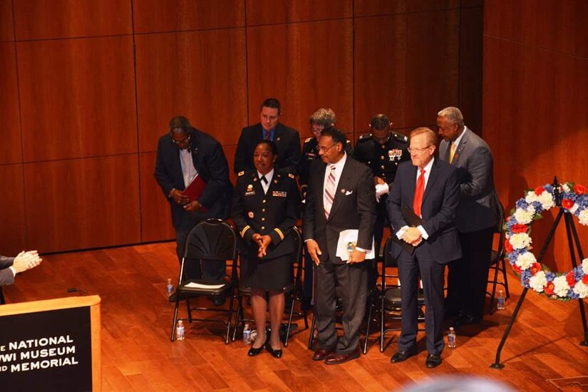 Colonel Bradford stands with other distinguished guest after giving her speech