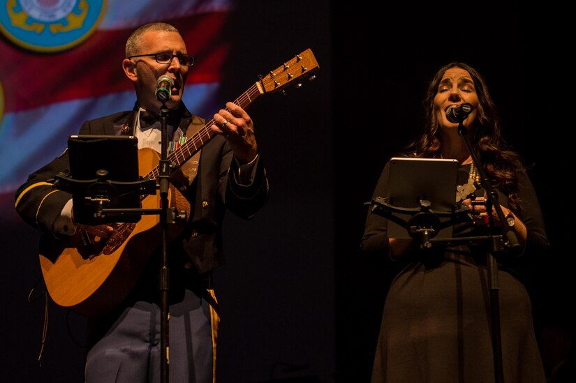 U.S. Army Spc. Andre Badeaux, U.S. Army Training and Doctrine Command Band musician, and his wife, Rae Badeaux, sing together at the Veterans Day Concert in Virginia Beach, Va., Nov. 11, 2016. The Badeauxs wrote and performed the song ‘Half of My Heart’ for their son and daughter-in-law, who are deployed. (U.S. Air Force photo by Airman 1st Class Derek Seifert)