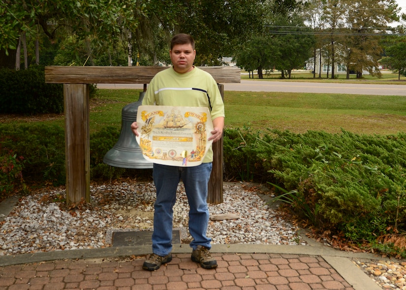 Joint Base Charleston Police officer Timothy Reed 628th Security Forces assigned to Naval Weapons station poses with his plankowners certificate, Nov 09, 2016. Reed was a member of the commissioning crew of the USS Arleigh Burke from 1993-1993.