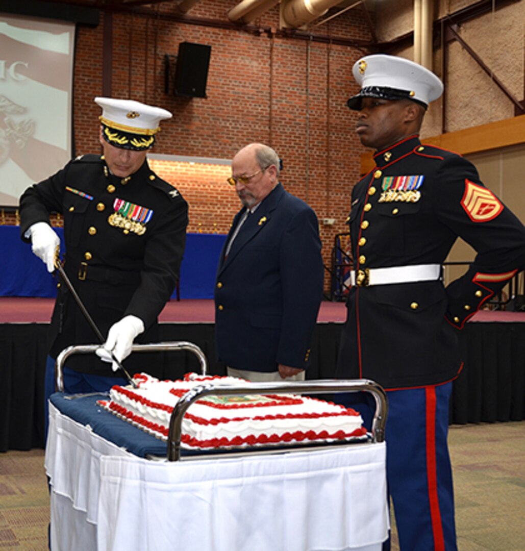 Marine Corps Col. A.J. Manuel begins the cake-cutting at the 241st Marine Corps birthday celebration at the Defense Supply Center Richmond, Virginia, on Nov. 10, 2016. DSCR's oldest Marine, David Jinnette and the youngest Marine, Sgt. Julian McGee watch and wait to taste the second piece of cake served. The first piece was served to the guest of honor, DLA Aviation Deputy Commander, Charlie Lilli. 