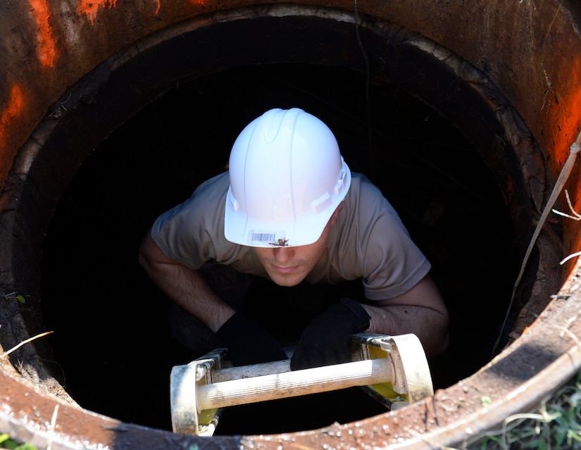 U.S. Air Force Airman 1st Class Austin Zudak, 633rd Communication Squadron cable and antenna apprentice, climbs out of a manhole after performing a routine cable inspection at Joint Base Langley-Eustis, Va., Nov. 15, 2016. Before entering the manhole, the Airmen pumped out the manhole, which fills regularly with rain and ground water. (U.S. Air Force photo by Kaylee Dubois)