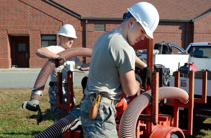 U.S. Air Force Staff Sgt. Michael LeMõn, 633rd Communication Squadron cable and antenna supervisor, and Airman 1st Class Austin Zudak, 633rd CS cable and antenna apprentice, unpack tubes to pump out a water-filled manhole at Joint Base Langley-Eustis, Va., Nov. 15, 2016. After pumping out the water, the technicians test the amount of gas in the manhole to ensure the safety of the Airmen entering the hole. Gas forms under the water due to its greater density. (U.S. Air Force photo by Kaylee Dubois)