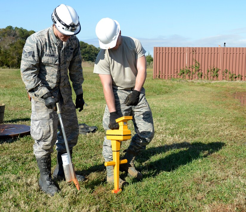 U.S. Air Force Senior Airman Bruce Winsemius, 633rd Communication Squadron cable and antenna technician, and Airman 1st Class Austin Zudak, 633rd Communication Squadron cable and antenna apprentice, mark the cable lines with spray paint at Langley Air Force Base, Va., Nov. 15, 2016. Using the electronic detection device, the cable and antenna team can map out the lines of cable throughout base. (U.S. Air Force photo by Kaylee Dubois)