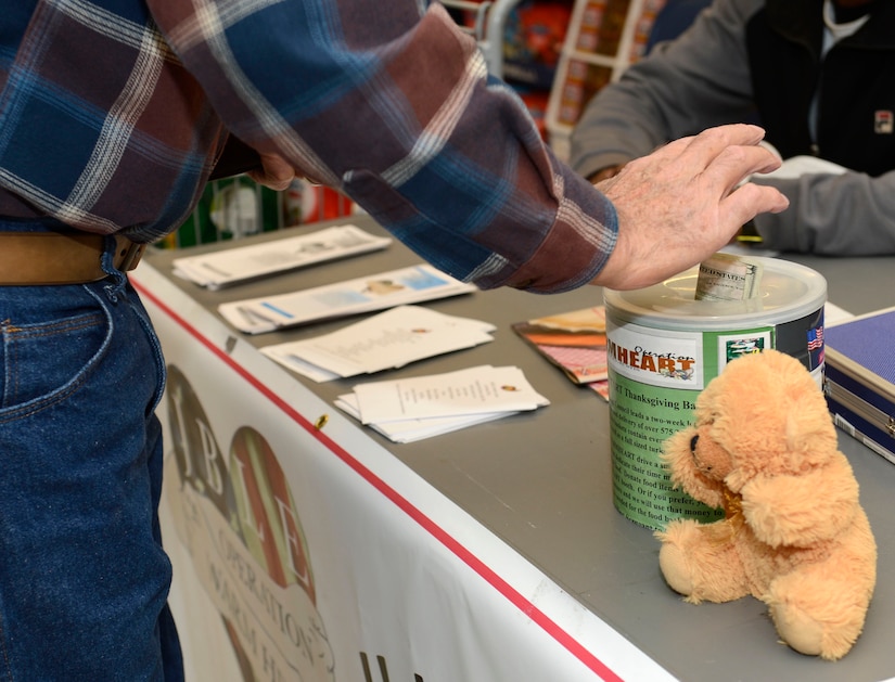 A commissary customer donates money to Operation Warmheart at Joint Base Langley-Eustis, Va., Nov. 15, 2016. Operation Warmheart is a nonprofit organization established by the First Sergeants Council to assist Joint Base Langley-Eustis service members and their families in need, through charitable funds raised throughout the year. (U.S. Air Force photo by Airman 1st Class Kaylee Dubois)
